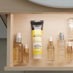 John Frieda Sheer Blonde Go Blonder Lightening Conditioner tube in organized minimalist bathroom skincare drawer next to aesthetic glass serum bottles