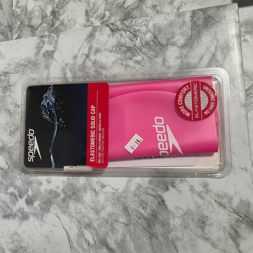 Front view of pink Speedo Elastomeric Solid Swim Cap in sealed clamshell packaging showing More Comfort Elastomeric badge