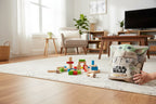 Star Wars Mandalorian Grogu plush in action playtime scenario in bright living room near building blocks on area rug