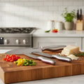 Cuisinart color band knives arranged on rustic wooden cutting board with chopped bell pepper and parmesan cheese for culinary preparation