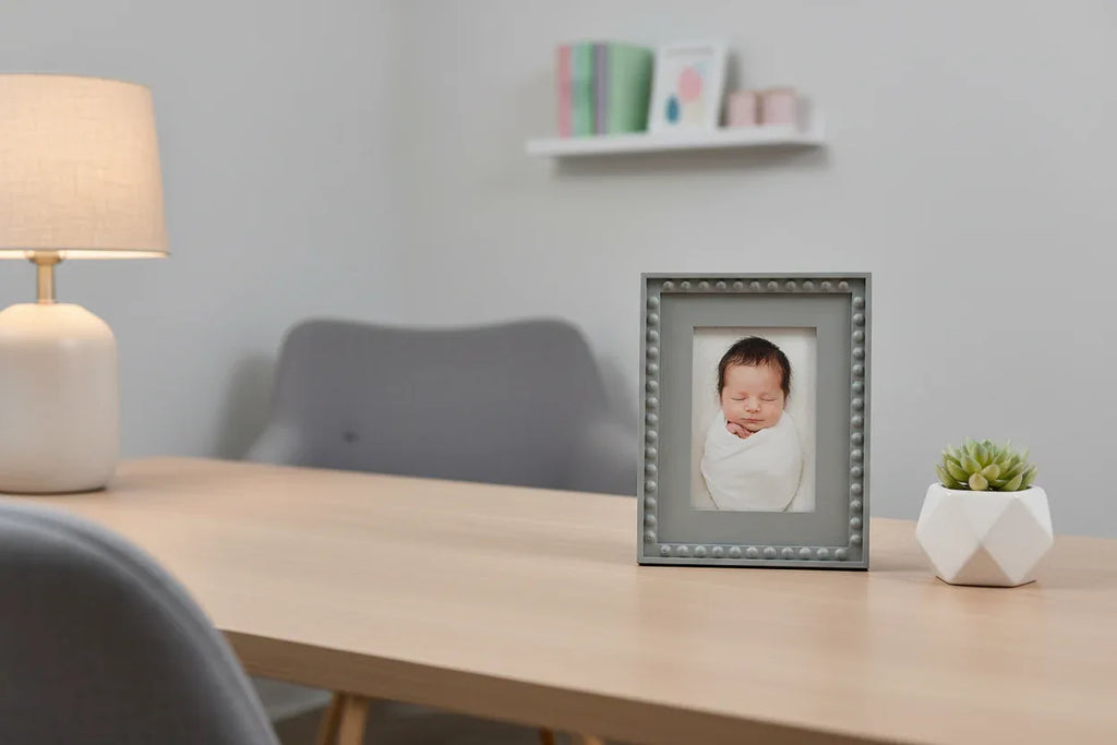 Modern nursery or office accent decor displaying a grey beaded 4x6 portrait frame on a desk