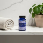 Motherlove Morning Sickness Blend bottle on bathroom quartz vanity with rolled cotton towel and green houseplant