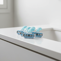 Light blue and white razor cartridges resting on a polished white bathroom vanity surface