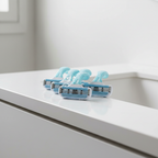 Light blue and white razor cartridges resting on a polished white bathroom vanity surface