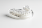 Macro shot of clear DenTek Professional-Fit dental guard showing dual-layer construction and custom-molded shape