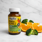 Prenatal multivitamin amber glass bottle beside fresh organic orange slices and broccoli on white marble – More4less Outlet
