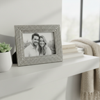 Silver-tone beaded picture frame on a white shelf with a portrait photo inside