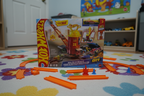 Hot Wheels City Super Fire Station Rescue box displayed on a kids bedroom floor with orange Hot Wheels track pieces