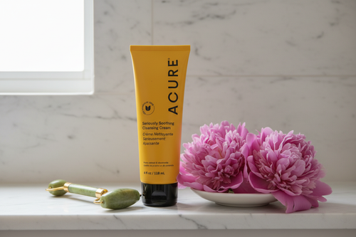 ACURE Seriously Soothing Cleansing Cream on bathroom shelf with peony flowers lifestyle
