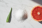 Glycolic acid crystals citrus slice and green leaf flat lay skincare ingredients lifestyle photo