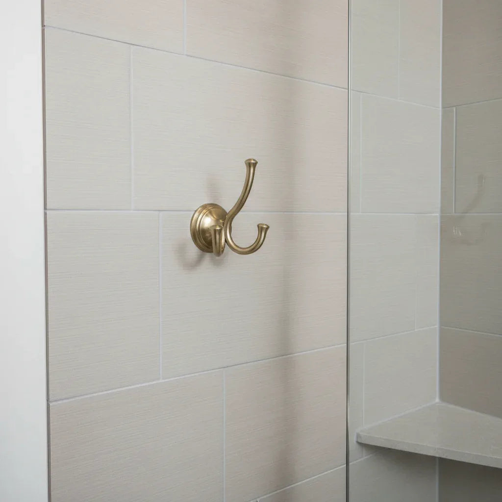 Minimalistic shower stall background complementing a clean champagne bronze Delta Cassidy towel mount