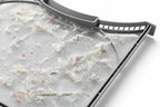 Close-up of fine gray mesh lint filter screen trapping debris under soft workshop lighting