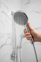 Grohe Euphoria 110 Duo polished chrome hand shower held in hand with water streaming in rain mode in luxury shower