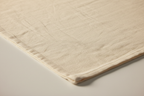 Macro detail of Eden Home cream garment-washed polyester fabric texture showing ultra-soft lived-in finish