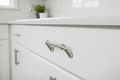 Baldwin Couture 4-inch cabinet pull satin nickel installed on white shaker kitchen cabinet drawer - More4less Outlet