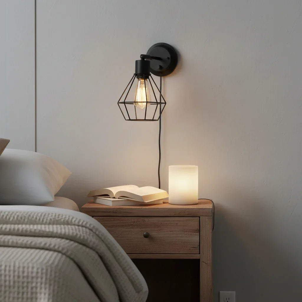 Globe Electric Evans matte black wire cage wall sconce mounted in bedroom above nightstand
