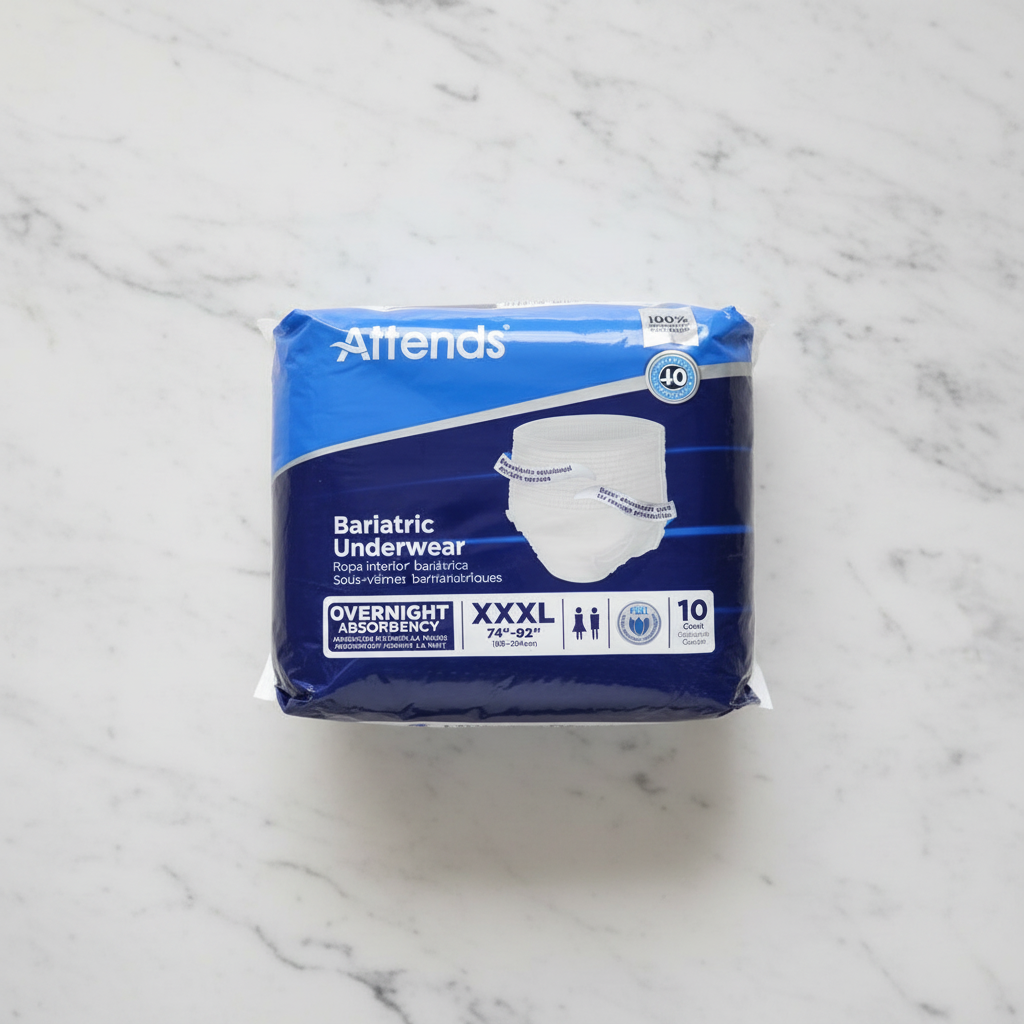Lifestyle flat lay of sealed blue Attends Bariatric Underwear XXXL package on white marble surface