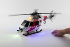 Maxx Action RH-1 911 helicopter toy with glowing lights and spinning rotors on white surface