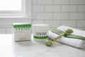 Rodan + Fields SOOTHE Rescue Mask white jar on marble vanity with jade roller aloe vera leaf and white towel sensitive skincare routine – More4less Outlet