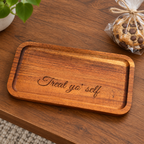 Treat Yo' Self engraved wood tray on a table beside a wrapped cookie