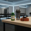 Nature's Truth L-Arginine HCl 1000mg bottle on wooden home gym counter with black matte shaker bottle and lifting straps