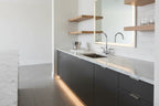 Clean contemporary home wet bar with high-polish chrome bar sink faucet on marble countertop