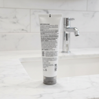 Arbonne Clarifying Detox Mask with Exfoliating Charcoal 5 oz on a marble bathroom counter near a sink
