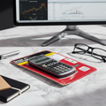 Texas Instruments BA II Plus financial calculator in original blister pack on clean marble desk professional finance product lifestyle