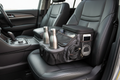 Auto Drive black car console organizer on SUV seat with two stainless steel water bottles in cup holders and mesh side pockets with phone and cables