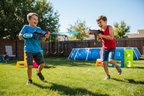 Two kids having a gel BB blaster battle outdoors, one wearing the Gelbee Flurry Glove mecha blaster — More4less Outlet