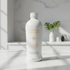 Sleek white aluminum botanical supplement drink bottle on bright white marble kitchen studio surface, soft natural light