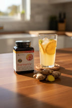 Youtheory Turmeric Extra Strength bottle on wooden breakfast bar next to orange water and organic ginger root