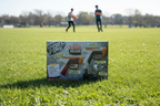 Nerf Pro Gelfire Dual Wield 2-Pack displayed outdoors on grass field in bright sunshine with teens playing in background