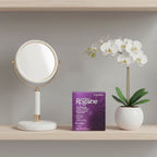 Women's Rogaine 3-Month Supply box on minimalist vanity shelf with designer hand mirror and fresh white orchid