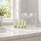 Mary Kay Satin Hands and Satin Lips tubes with clear tote on a marble bathroom vanity