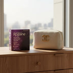 Women's Rogaine 3-Month Supply box next to designer cosmetics bag on modern wood dresser with morning sunlight