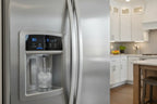 Clean modern stainless steel refrigerator with ice and water dispenser panel in focus
