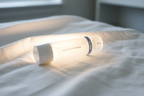 Rodan + Fields REDEFINE Pore Refining Toner bottle on white linen with soft radiant skincare glow aesthetic