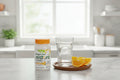 Fergon Iron Restore supplement bottle on kitchen counter beside glass of water and sliced citrus