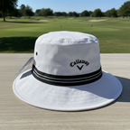 Close view of the Callaway Golf white and black bucket hat on a golf-course table