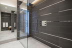 Modern luxurious finished shower interior with sleek tile walls and polished chrome trim plate