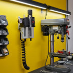 ARO FRL unit mounted on yellow workshop wall next to industrial drill press with black coiled air hose connected