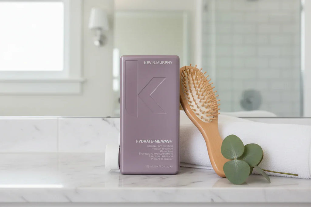 KEVIN.MURPHY HYDRATE-ME.WASH on marble bathroom shelf with brush and towel lifestyle