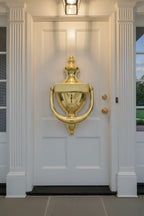 Baldwin 0102 Colonial Door Knocker Polished Brass on white painted wood door with architectural columns and porch lighting