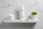 Jan Marini C-ESTA Cleansing Gel on bathroom shelf with face brush and plant lifestyle