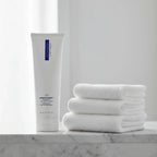 ZO Medical Normacleanse hydrating cleanser on stone bathroom shelf with fluffy white towels spa aesthetic