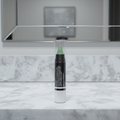 Mary Kay At Play Color Correcting Stick Wipe Out Redness — white cylindrical twist-up stick with clear cap and green cream corrector tip standing upright on a white marble vanity with soft clean lighting and blurred mirror