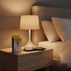 Burt's Bees Herbal Blemish Patch box on light-oak bedside table with sleep mask and soft-lit table lamp