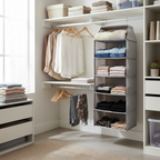 Organized bedroom closet with light grey fabric hanging shelf organizer filled with neatly folded clothes in modern closet