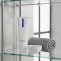 ZO Medical Foamacleanse on glass bathroom shelf with gray towel and porcelain bowl